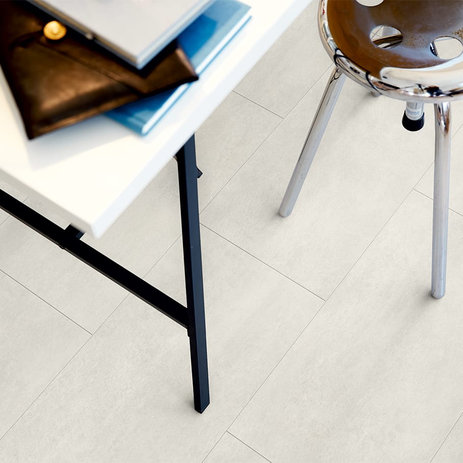 close up of a desk with chair and a grey vinyl tile floor